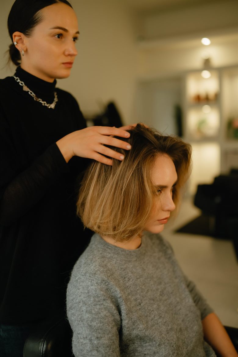 A stylist working carefully through a client’s colour in the salon.